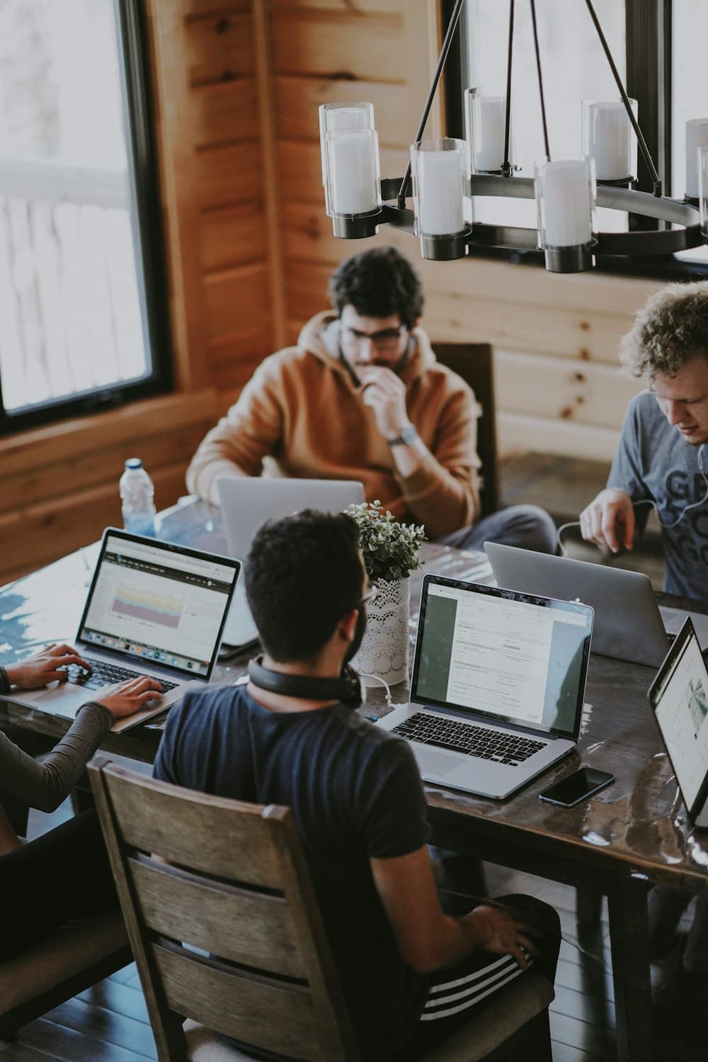 A group collaborating around a table with laptops